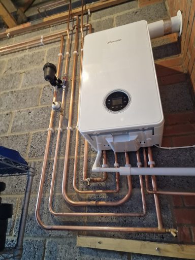 Worcester Bosch combi boiler installed in a garage. Neat copper pipework, showcasing professional Gas Safe workmanship and quality finish