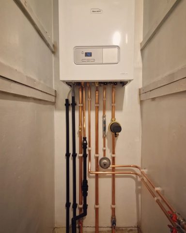 A Glowworm combination boiler beautifully installed in an airing cupboard with clean, precise copper pipework and attention to detail.